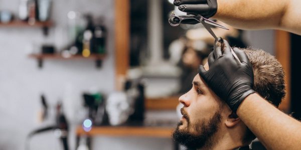 cliente-facendo-taglio-di-capelli-in-un-salone-di-barbiere_1303-20735