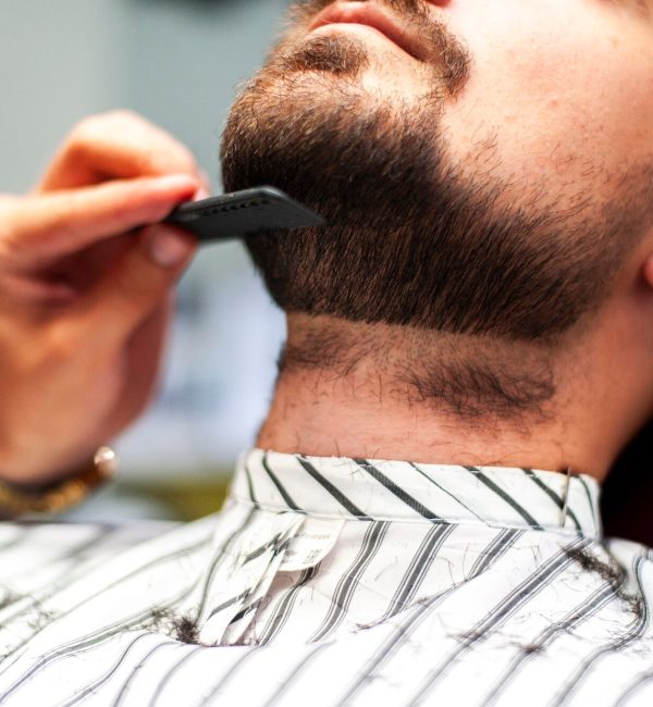 parrucchiere-che-pettina-la-barba-del-cliente_23-2148256922