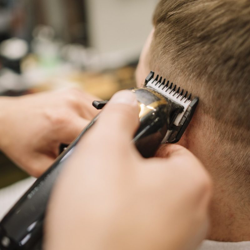vista-del-primo-piano-dell-uomo-che-ottiene-un-taglio-di-capelli_23-2148506364
